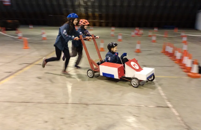 Scouts pushing a kart