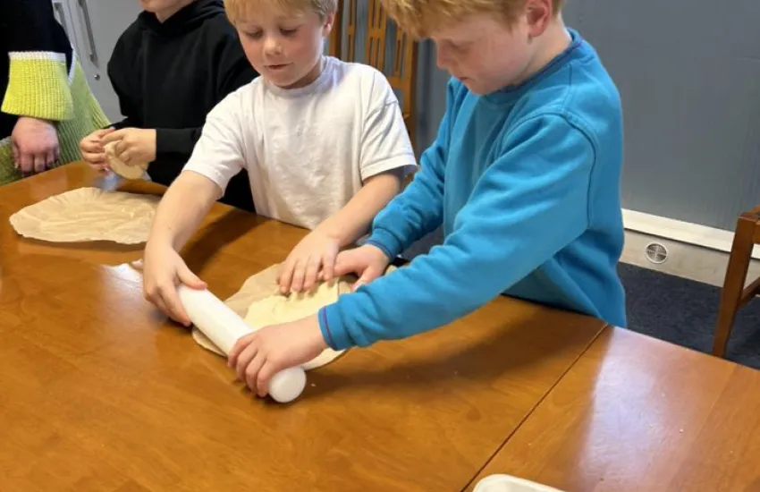 two beavers rolling out pizza dough
