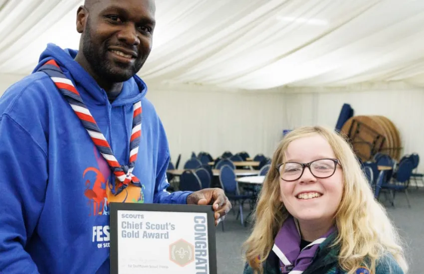 a scout is awarded their Gold Award by UK Chief Scout Dwayne Fields