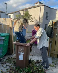 An explorer crushes garden waste in a bin
