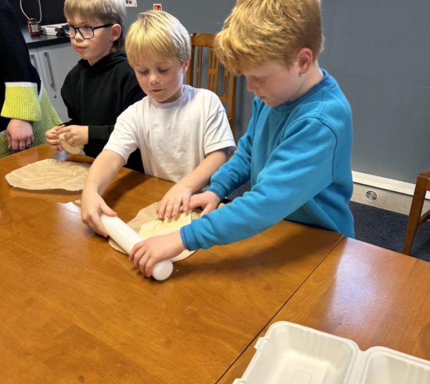 two beavers rolling out pizza dough