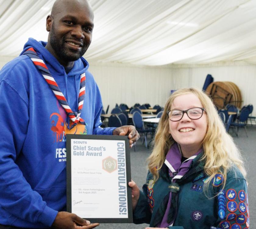 a scout is awarded their Gold Award by UK Chief Scout Dwayne Fields